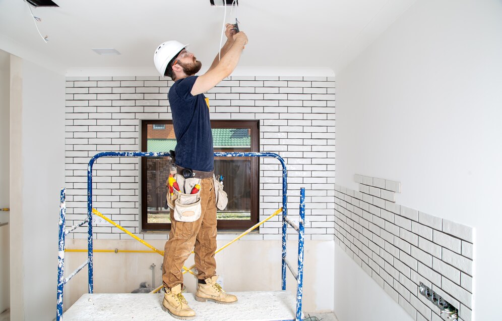 Electrician in overalls with tools